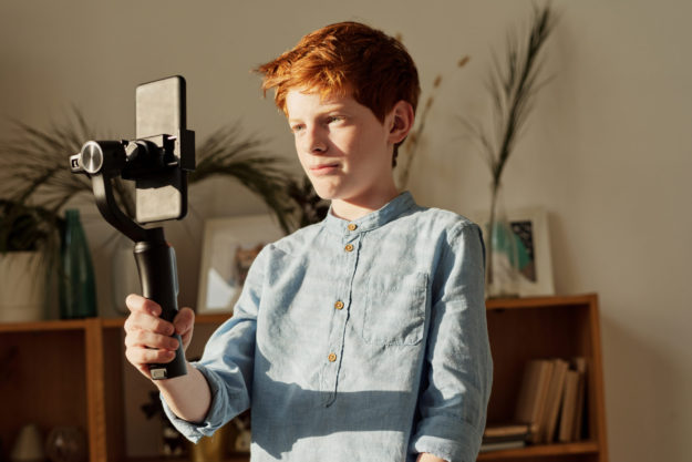 boy-in-blue-dress-shirt-holding-black-selfie-stick-4145248